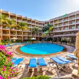 Basen hotelowy Beau Rivage z leżakami i palmami, otoczony budynkami hotelowymi.