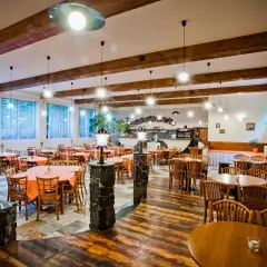 Szukasz miejsca, gdzie zjeść w Mielnie? Przytulna restauracja z drewnianymi belkami i stołami nakrytymi pomarańczowymi obrusami zaprasza.