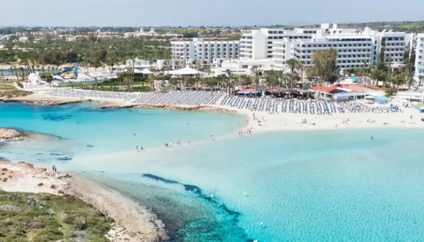 Piękna plaża z turkusową wodą i białymi hotelami. Czy Cypr to państwo, które oferuje takie widoki? Tak, to raj dla turystów!