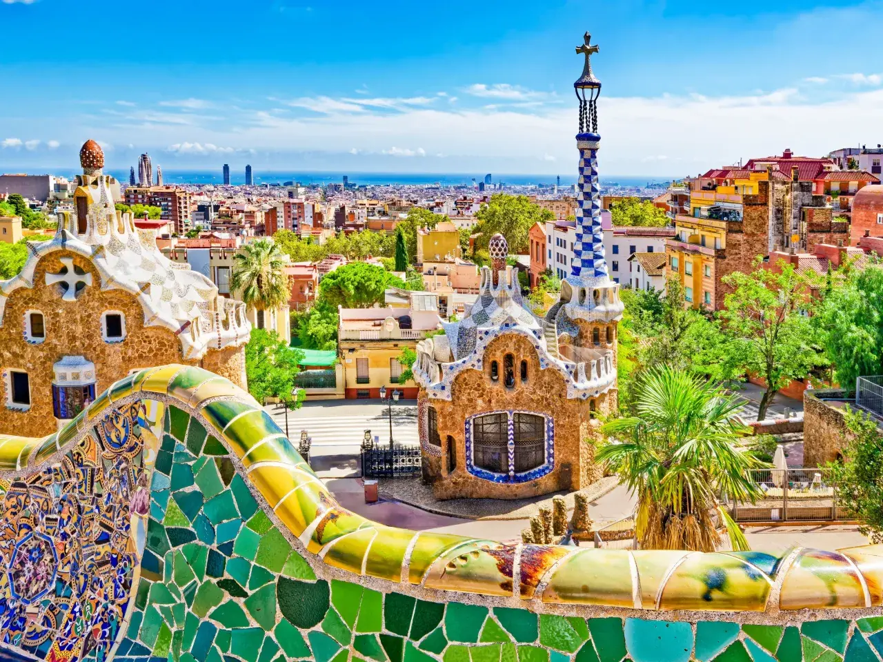 Kolorowe mozaiki Parku Güell w Barcelonie, idealne miejsce na nocleg w Barcelonie. Widok na miasto i morze.