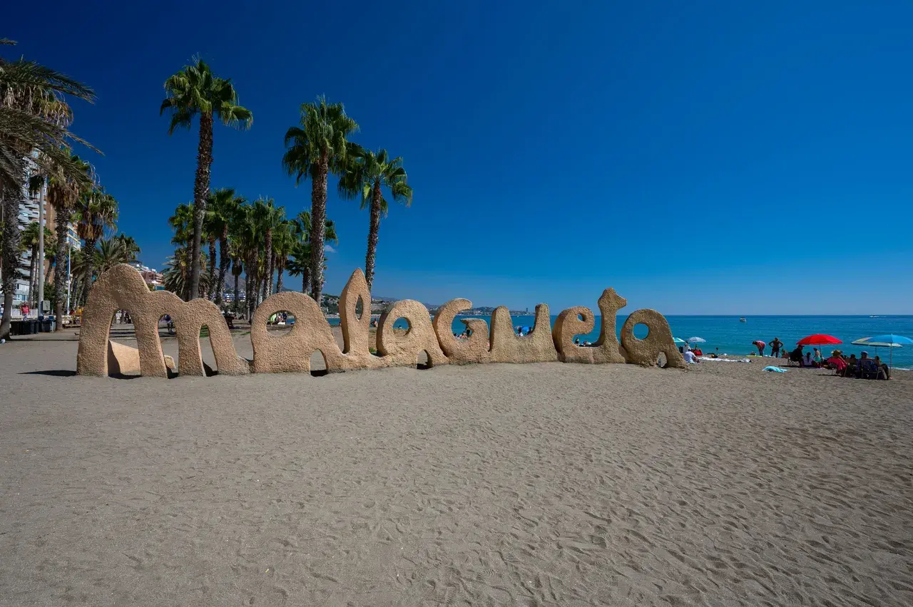 Piaskowy napis "Malagueta" na plaży, palmy i błękitne morze. Czy Malaga ma dostęp do morza? Tak, jak widać!