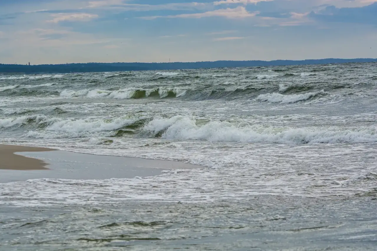 Fale rozbijają się o brzeg. Zastanawiasz się, co robić zimą nad morzem? Spacer po plaży i podziwianie żywiołu to świetny pomysł!