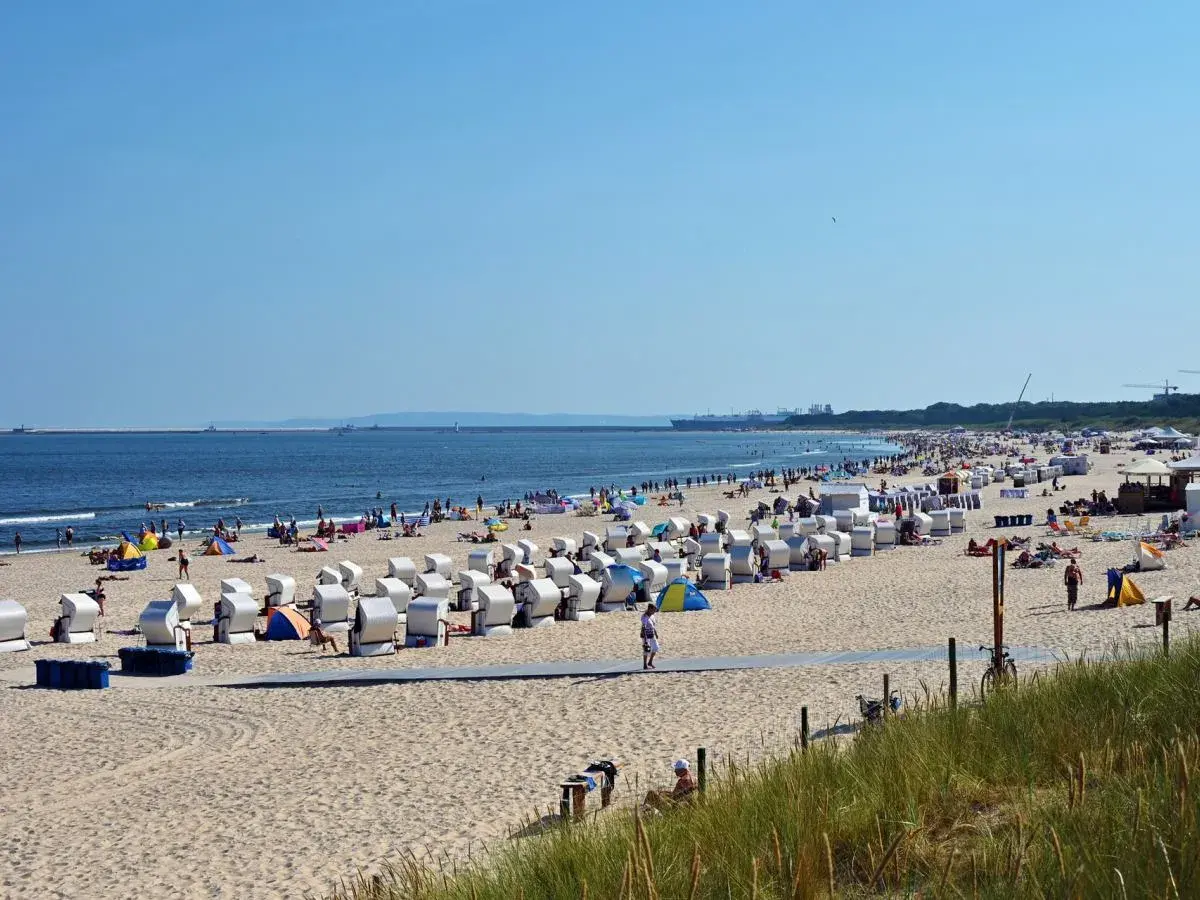 Słoneczna plaża pełna turystów, leżaków i parawanów. Woda w Bałtyku w lipcu jest przyjemna, idealna do kąpieli.